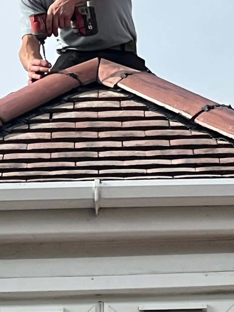 This is a photo of one of the operatives of Great Barr Roofing Repairs installing new ridge tiles